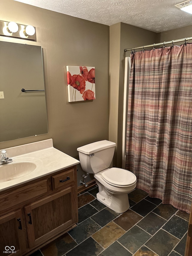 545 Walnut Woods Dr, Greenwood, IN 46142 - full bathroom featuring stone tile floors, toilet, a textured ceiling, vanity, and curtained shower