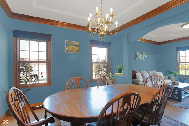 545 Walnut Woods Dr, Greenwood, IN 46142 - dining space with wood finished floors, a raised ceiling, a chandelier, arched walkways, and baseboards