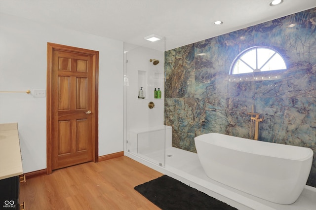 545 Walnut Woods Dr, Greenwood, IN 46142 - bathroom featuring wood finished floors, a walk in shower, a freestanding bath, recessed lighting, and baseboards