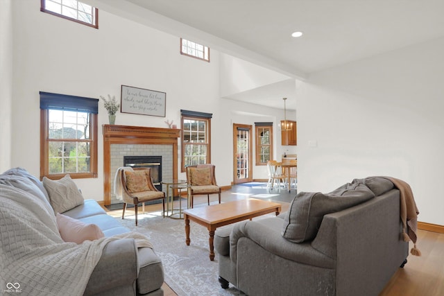 545 Walnut Woods Dr, Greenwood, IN 46142 - living room featuring healthy amount of natural light, wood finished floors, a brick fireplace, recessed lighting, and baseboards