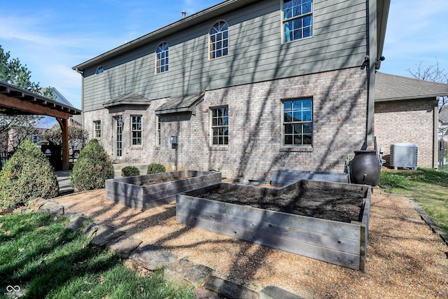 545 Walnut Woods Dr, Greenwood, IN 46142 - back of house with a garden, brick siding, and cooling unit