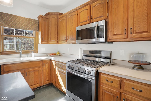 545 Walnut Woods Dr, Greenwood, IN 46142 - kitchen featuring stainless steel appliances, a sink, light countertops, and dark tile patterned floors