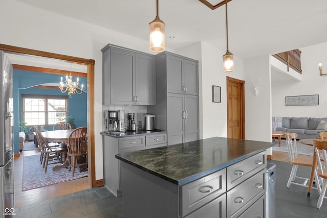 545 Walnut Woods Dr, Greenwood, IN 46142 - kitchen with gray cabinetry, dark countertops, a chandelier, hanging light fixtures, and open floor plan