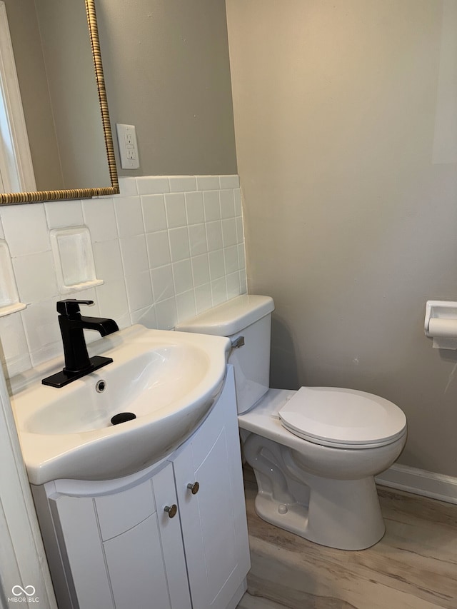 10328 Central Ave, Carmel, IN 46280 - half bathroom featuring toilet, vanity, wood finished floors, tile walls, and baseboards