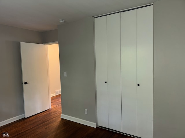 10328 Central Ave, Carmel, IN 46280 - unfurnished bedroom featuring dark wood-style flooring, a closet, and baseboards