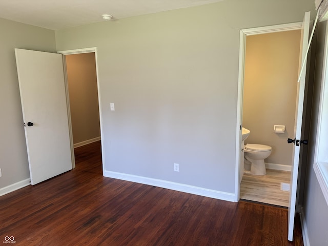 10328 Central Ave, Carmel, IN 46280 - unfurnished bedroom with baseboards, dark wood-type flooring, and ensuite bath