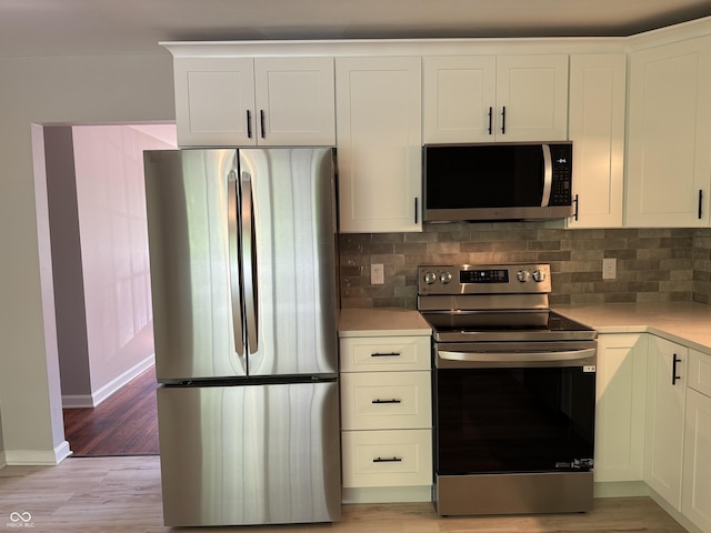 10328 Central Ave, Carmel, IN 46280 - kitchen with appliances with stainless steel finishes, light countertops, tasteful backsplash, baseboards, and light wood-style floors