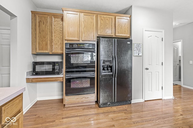 14353 Chariots Whisper Dr, Carmel, IN 46074 - kitchen featuring black appliances, light wood finished floors, baseboards, and light countertops