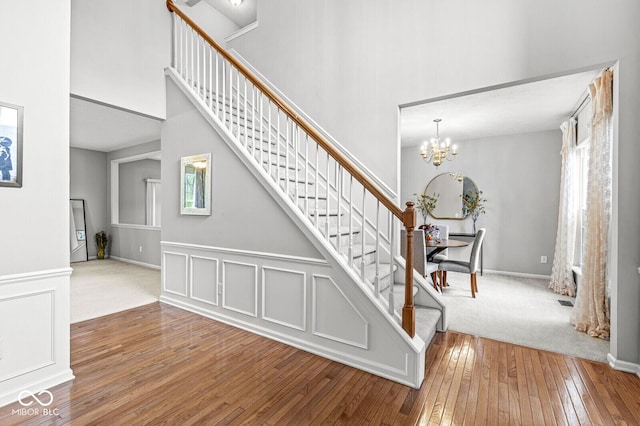14353 Chariots Whisper Dr, Carmel, IN 46074 - stairway with hardwood / wood-style floors, a high ceiling, and a chandelier