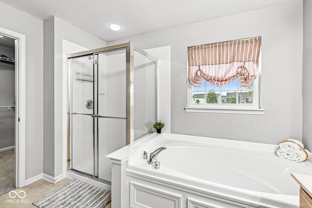 14353 Chariots Whisper Dr, Carmel, IN 46074 - full bathroom with a garden tub, a shower stall, a walk in closet, tile patterned floors, and a textured ceiling