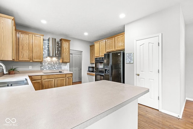 14353 Chariots Whisper Dr, Carmel, IN 46074 - kitchen with black appliances, a sink, wall chimney range hood, backsplash, and light wood-style flooring