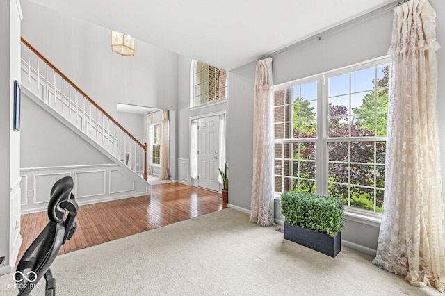 14353 Chariots Whisper Dr, Carmel, IN 46074 - foyer featuring carpet floors, healthy amount of natural light, stairway, and wood-type flooring