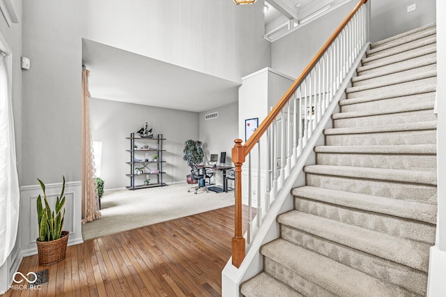 14353 Chariots Whisper Dr, Carmel, IN 46074 - stairway featuring a towering ceiling and hardwood / wood-style floors