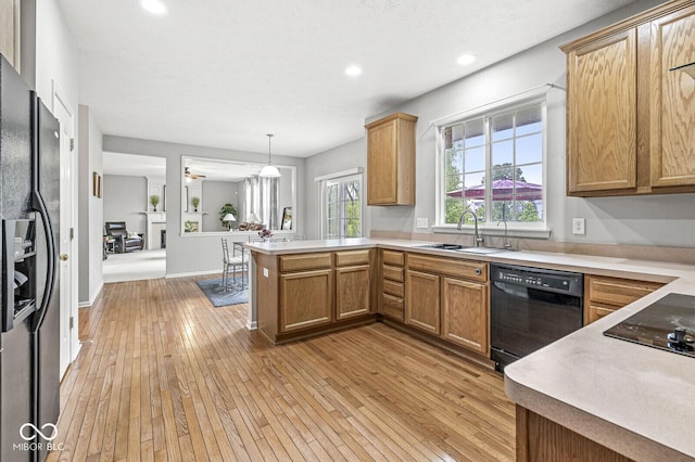 14353 Chariots Whisper Dr, Carmel, IN 46074 - kitchen with black appliances, a sink, a peninsula, light wood-style flooring, and recessed lighting