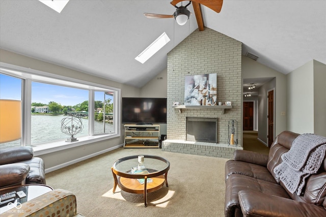 101 Edgewater Dr, Noblesville, IN 46062 - carpeted living room featuring a skylight, a ceiling fan, a brick fireplace, and baseboards