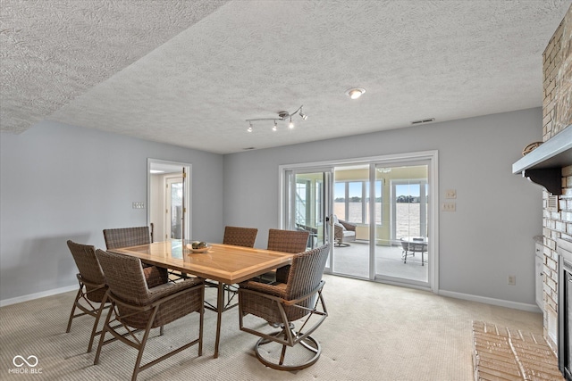 101 Edgewater Dr, Noblesville, IN 46062 - dining space featuring a large fireplace, baseboards, light carpet, and a textured ceiling