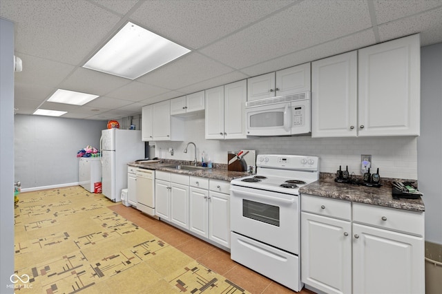 101 Edgewater Dr, Noblesville, IN 46062 - kitchen with white appliances, a paneled ceiling, dark countertops, a sink, and white cabinetry