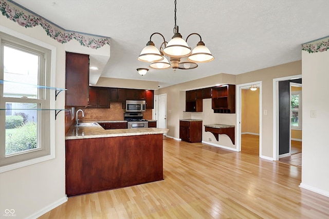 8331 Tequista Ct, Indianapolis, IN 46236 - kitchen with appliances with stainless steel finishes, light wood-style flooring, baseboards, a sink, and a chandelier