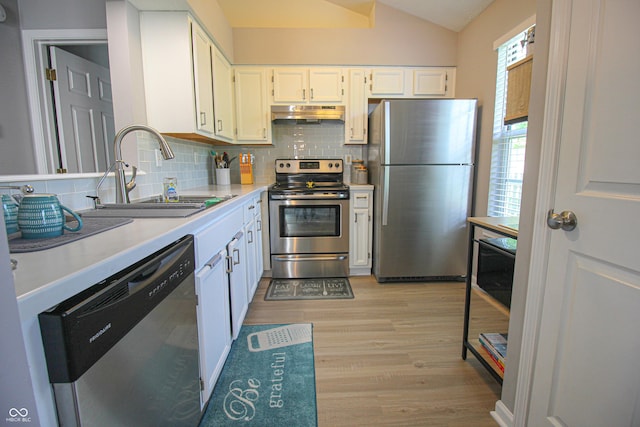 9774 Foxboro Ln, Fishers, IN 46038 - kitchen with stainless steel appliances, a sink, under cabinet range hood, tasteful backsplash, and vaulted ceiling