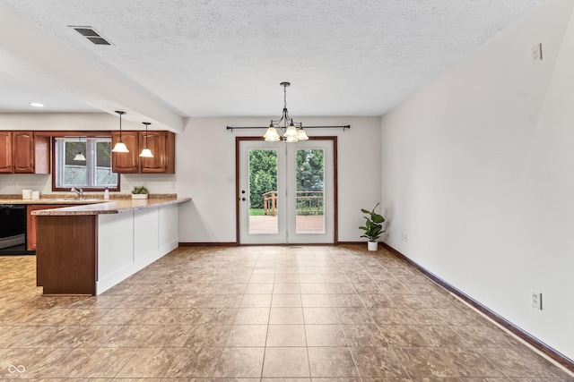 7426 N Carroll Rd, Indianapolis, IN 46236 - kitchen featuring plenty of natural light, a peninsula, pendant lighting, light countertops, and a textured ceiling