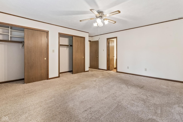 7426 N Carroll Rd, Indianapolis, IN 46236 - unfurnished bedroom featuring two closets, light colored carpet, a ceiling fan, and ornamental molding