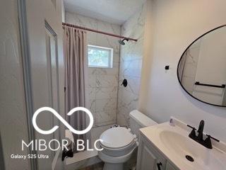 2421 N Arsenal Ave, Indianapolis, IN 46218 - bathroom featuring vanity, a shower with curtain, and toilet