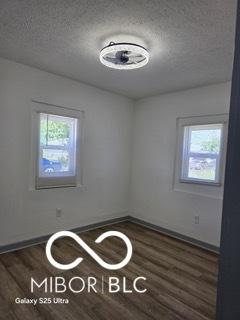 2421 N Arsenal Ave, Indianapolis, IN 46218 - unfurnished room featuring plenty of natural light, wood finished floors, a textured ceiling, and baseboards