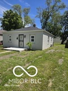 2421 N Arsenal Ave, Indianapolis, IN 46218 - view of front facade with a front yard and stucco siding