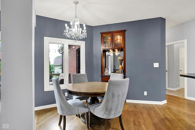 14492 Allison Dr, Carmel, IN 46033 - dining room with a chandelier, light wood-style floors, and baseboards