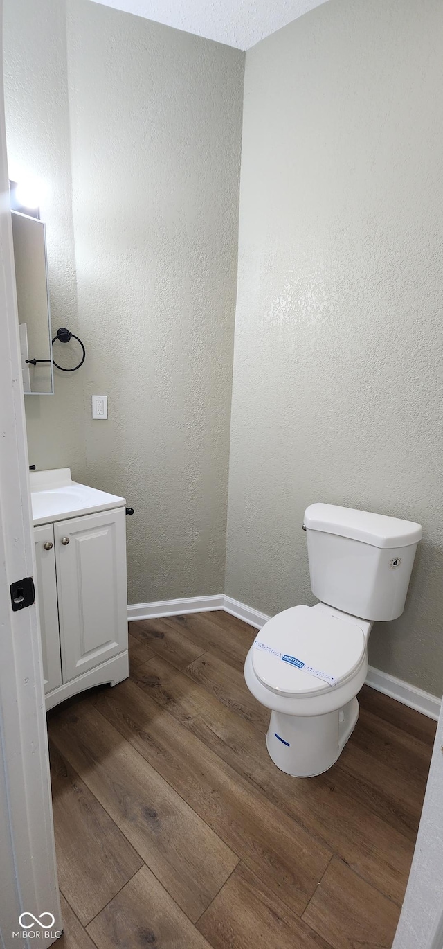 709 N Sterling Ave, Veedersburg, IN 47987 - bathroom with toilet, wood finished floors, vanity, and baseboards