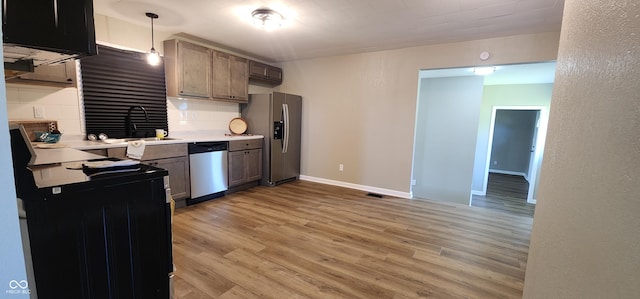 709 N Sterling Ave, Veedersburg, IN 47987 - kitchen with stainless steel appliances, light wood-style flooring, light countertops, a sink, and baseboards
