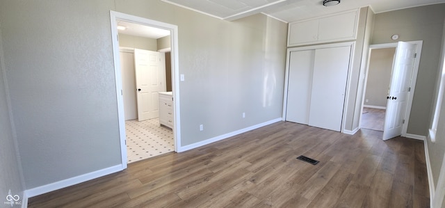 709 N Sterling Ave, Veedersburg, IN 47987 - unfurnished bedroom with a closet, wood finished floors, ensuite bathroom, and baseboards