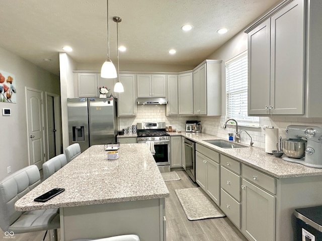 9133 Thames Dr, Avon, IN 46123 - kitchen featuring stainless steel appliances, a sink, light wood-style flooring, a breakfast bar area, and a center island
