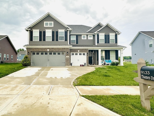 9133 Thames Dr, Avon, IN 46123 - view of front of house with a garage, driveway, a front yard, cooling unit, and brick siding