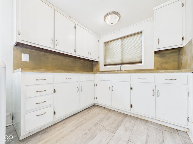 907 S A St, Elwood, IN 46036 - kitchen featuring white cabinetry, light wood-style flooring, and light countertops
