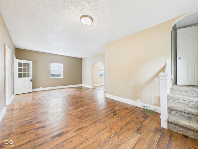 907 S A St, Elwood, IN 46036 - spare room featuring arched walkways, wood finished floors, a textured ceiling, and baseboards
