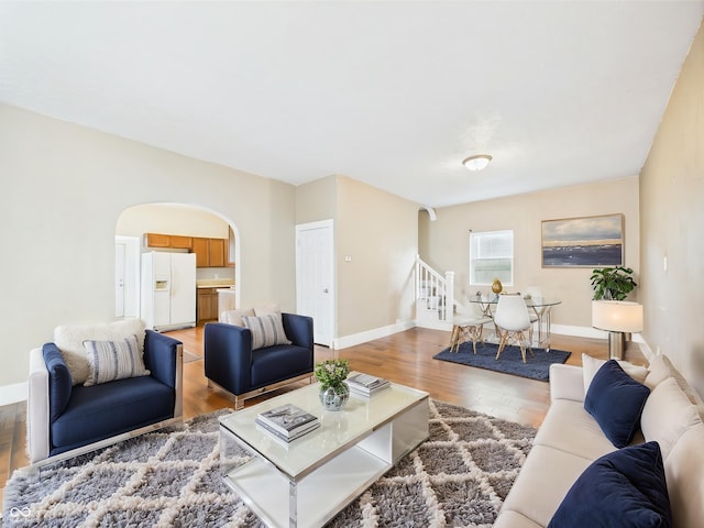 907 S A St, Elwood, IN 46036 - living area featuring arched walkways, stairs, light wood-type flooring, and baseboards