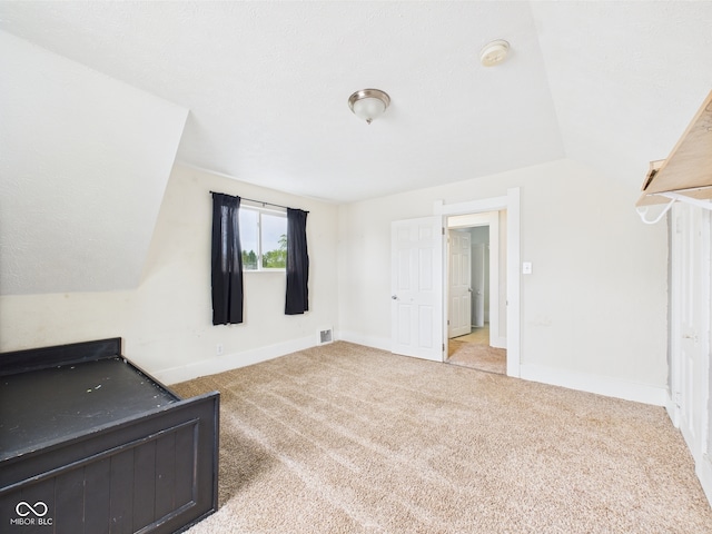 907 S A St, Elwood, IN 46036 - unfurnished bedroom with carpet, vaulted ceiling, and baseboards