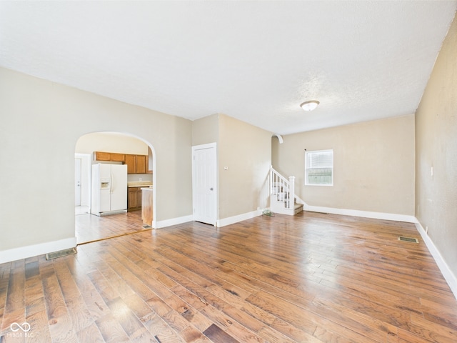 907 S A St, Elwood, IN 46036 - unfurnished room with arched walkways, stairs, hardwood / wood-style floors, and baseboards
