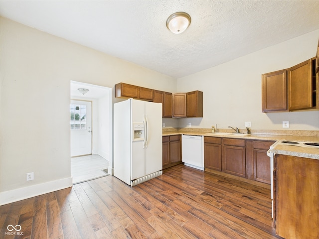 907 S A St, Elwood, IN 46036 - kitchen featuring white appliances, a sink, brown cabinetry, light countertops, and dark wood finished floors