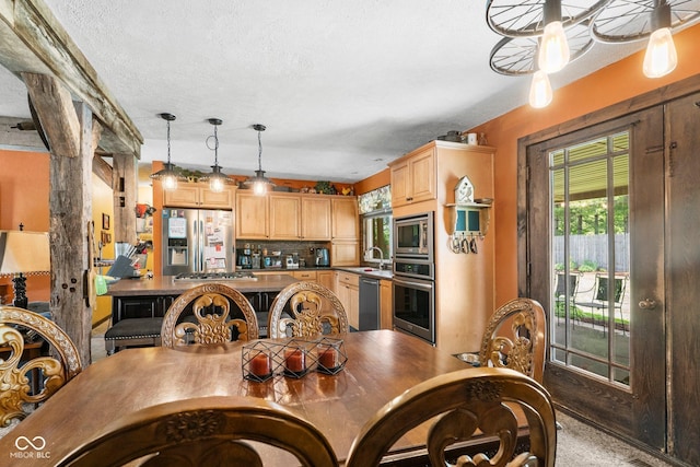 3480 W Broadus Dr, North Vernon, IN 47265 - kitchen with stainless steel appliances, light brown cabinets, tasteful backsplash, hanging light fixtures, and a textured ceiling