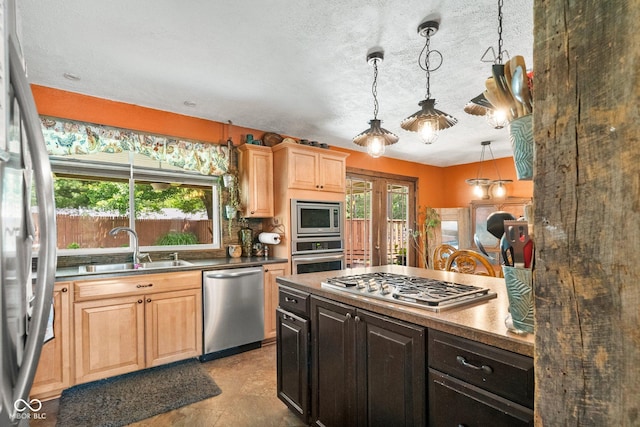 3480 W Broadus Dr, North Vernon, IN 47265 - kitchen with stainless steel appliances, a sink, light brown cabinets, pendant lighting, and dark countertops