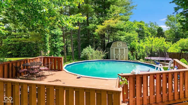 3480 W Broadus Dr, North Vernon, IN 47265 - view of swimming pool featuring a trampoline, a deck, and view of scattered trees