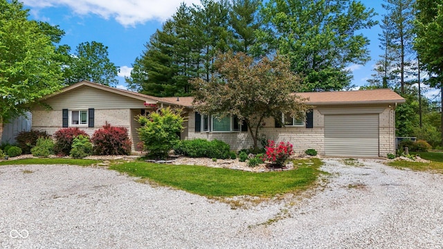 3480 W Broadus Dr, North Vernon, IN 47265 - ranch-style house featuring gravel driveway, a garage, and brick siding
