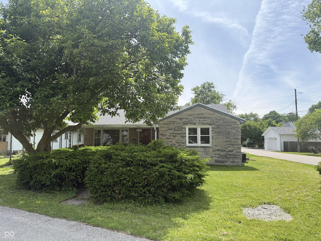 222 Hanley St, Plainfield, IN 46168 - view of front of property with stone siding, a front lawn, a detached garage, and concrete driveway