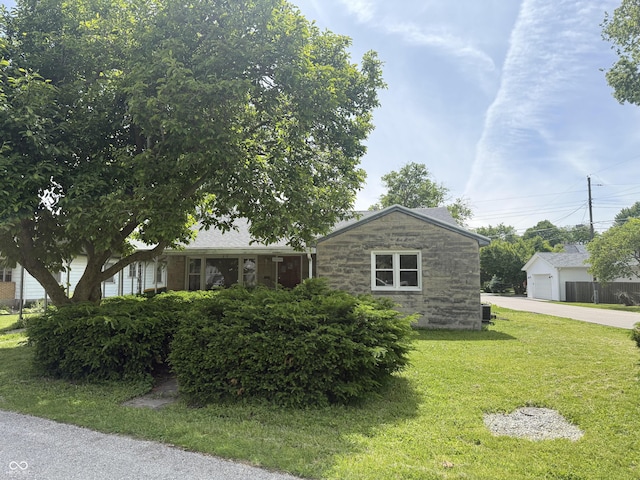 222 Hanley St, Plainfield, IN 46168 - view of front of property with stone siding, a front lawn, a detached garage, and concrete driveway