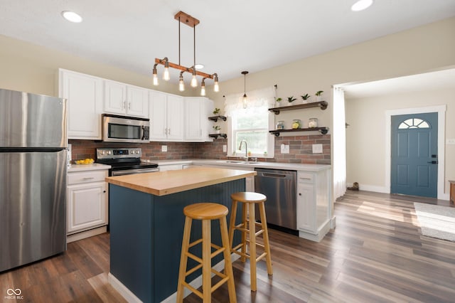 3360 Main St, Plainfield, IN 46168 - kitchen featuring stainless steel appliances, wood counters, open shelves, white cabinetry, and recessed lighting