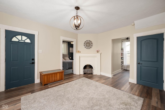 3360 Main St, Plainfield, IN 46168 - unfurnished living room featuring a chandelier, dark wood-style floors, baseboards, and a brick fireplace