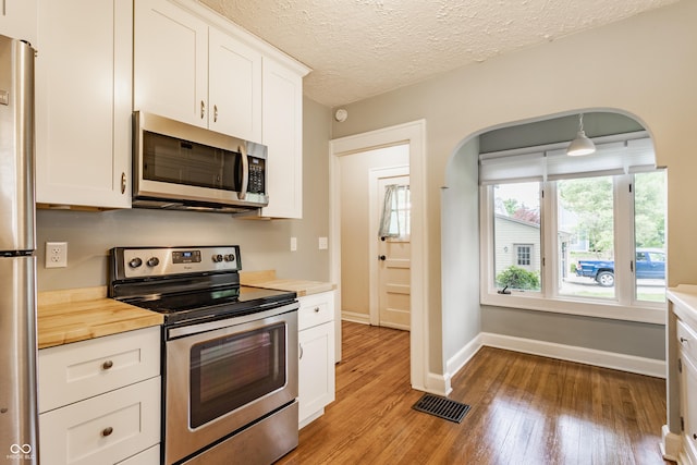 595 W Poplar St, Zionsville, IN 46077 - kitchen featuring stainless steel appliances, light wood-style flooring, wooden counters, arched walkways, and white cabinets