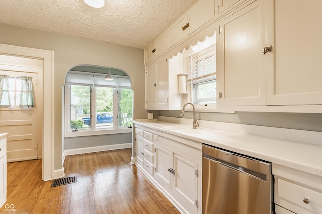 595 W Poplar St, Zionsville, IN 46077 - kitchen with dishwasher, light wood-style floors, white cabinetry, and a textured ceiling